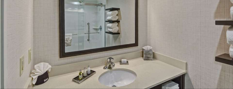 A Standard room bathroom with single sink vanity and tub shower unit at the Black Fox Lodge in Pigeon Forge Tn