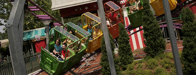 Kids in the colorful Junior size coaster Slideshow Spin in Dollywood wide